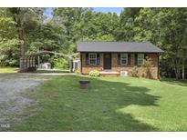 Charming brick home with a well-maintained lawn, carport and an outbuilding for extra storage at 437 Woodsdale Rd, Roxboro, NC 27573