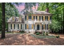 Charming two-story home with black shutters, a brick chimney, and mature landscaping at 5113 Linksland Dr, Holly Springs, NC 27540