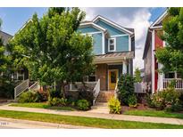 Charming two-story home features a yellow door, brick accents, a well-manicured lawn, and mature trees at 644 Granite Mill Blvd, Chapel Hill, NC 27516