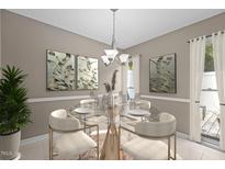 Bright dining room features a modern chandelier, a glass table set for four, and neutral wall decor at 7159 Sandy Creek Dr, Raleigh, NC 27615