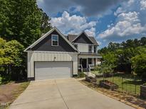 Charming two-story home featuring white siding, a gray roof, an attached two-car garage, and a well-maintained front lawn at 723 Lindley Dr, Durham, NC 27703