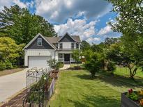 Charming two-story home with a landscaped yard, garden beds, and a spacious driveway and a two-car garage at 723 Lindley Dr, Durham, NC 27703