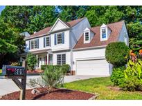 Charming two-story home features a manicured front yard and a two-car garage at 809 Green Passage Ln, Apex, NC 27502