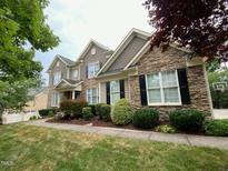 Charming two-story home with a stone and siding exterior and a well-manicured lawn at 9433 Collingdale Way, Raleigh, NC 27617