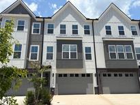 View of new construction townhome with a gray garage door and white and gray accents on the exterior at 1007 Regalia Rd # 31, Durham, NC 27713