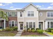Charming multi-story townhome featuring a well-manicured front yard and a welcoming entrance at 109 Grey Elm Trl, Durham, NC 27713
