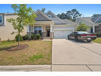 Charming home with a well-manicured lawn, gray siding, covered porch, and driveway with a car parked out front at 136 Durie Way, Garner, NC 27529
