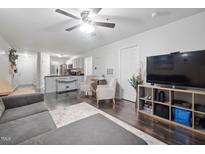 Open concept living room with ceiling fan, hardwood floors, and view of kitchen at 1851 Trailwood Heights Ln # 201, Raleigh, NC 27603