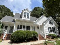 Charming two-story home with a white exterior, dormer, and inviting front porch at 3212 Potthast Ct, Raleigh, NC 27529