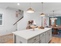 Bright, open kitchen with large island, pendant lighting, and modern white cabinets at 328 Cottage Hill Way, Knightdale, NC 27604