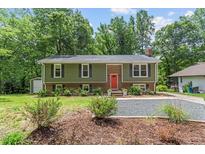Charming two-story home with brick and vinyl siding, an orange door and a well-manicured lawn at 4404 Oak Park Rd, Raleigh, NC 27612