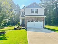 Charming two-story home with stone accents, a well-manicured lawn, and a spacious two-car garage at 50 Teal Dr, Youngsville, NC 27596