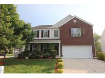 Two-story home with brick and siding, complemented by a well-manicured lawn and vibrant, mature landscaping at 5456 Thunderidge Dr, Raleigh, NC 27610