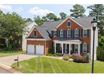 Beautiful two-story brick home with a manicured lawn, two-car garage, and a welcoming front porch at 8106 Sommerwell St, Raleigh, NC 27613