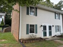 Two-story home with light siding, brick accents, green shutters, and a well-maintained lawn at 1136 Nottingham Cir, Cary, NC 27511