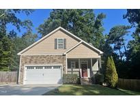 Charming home with a two-car garage, manicured lawn, and a mix of stone and shingle exterior at 120 Glen Oaks Dr, Youngsville, NC 27596