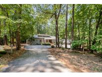 Secluded gray home with a lush, wooded lot and long driveway at 127 Creekwood, Pittsboro, NC 27312