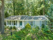 Charming single-story home with gray shutters and a wooded lot, creating a private and serene setting at 1317 Elmset Ln, Durham, NC 27713