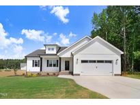Beautifully designed two-story home featuring white siding, black accents, and a well-manicured lawn at 157 Cherrybirch Ln, Zebulon, NC 27597