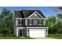 Charming two-story home featuring a classic design, attached garage, and well-manicured lawn at 219 Faith Avenue, Sanford, NC 27330