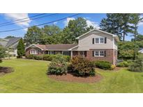 Charming two-story brick home featuring lush landscaping, well-manicured lawn, and classic black shutters at 315 Crescent Dr, Clayton, NC 27520