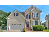 Charming two-story home with neutral siding, brick steps, a two-car garage, and manicured front landscaping at 3212 Marblewood Ct, Raleigh, NC 27604