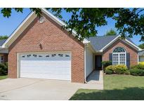 Charming brick home featuring an attached two-car garage and well-manicured front lawn, perfect for suburban living at 325 Millet Dr, Morrisville, NC 27560