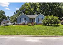 Charming blue home featuring a well-manicured front yard and inviting entrance at 5105 Baywood Forest Dr, Knightdale, NC 27545