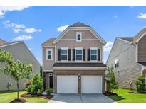 Two-story home showcasing a two-car garage, brick accents, and a well-manicured lawn at 1022 Homecoming Way, Durham, NC 27703