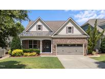 Charming brick home with attached two car garage and manicured front lawn landscaping at 120 Silver Bluff St, Holly Springs, NC 27540