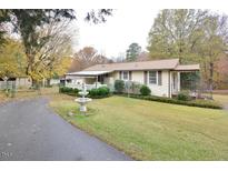 Charming home with manicured landscaping, covered porch, fountain, and a long driveway at 124 Jack Bennett Rd, Chapel Hill, NC 27517