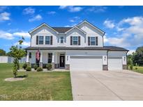 Charming two-story home with a three-car garage and a well-manicured lawn in a residential neighborhood at 175 Steep Rock Dr, Willow Springs, NC 27592