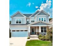 Beautiful two-story home with manicured lawn, attached garage and inviting front porch at 1880 Woodall Crest Dr, Apex, NC 27502