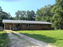 Charming single-story brick home featuring a metal roof, large front yard, and long driveway at 2306 Cool Springs Rd, Sanford, NC 27330