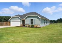 Charming single-story home with light blue siding, stone accents, and a well-manicured lawn at 25 Harlow Ct, Fuquay Varina, NC 27526