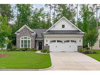 Charming home featuring a stone and white exterior, well-manicured lawn, and a two-car garage at 2511 Range Overlook Xing, Apex, NC 27523