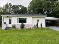 Charming single-story home with a white exterior, brick accents, and a well-manicured front lawn at 331 E Lillington St, Angier, NC 27501