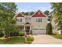 Inviting two-story home featuring a charming front porch and a convenient two-car garage at 3806 Stoneybrook Dr, Durham, NC 27705
