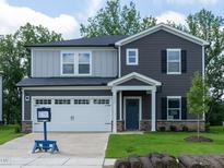 Charming two-story home with a well-manicured lawn, attached garage, and neutral-toned siding at 3845 Rosebush Dr, Zebulon, NC 27597