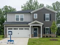 Charming two-story home featuring a two-car garage, stone accents, and a well-manicured front lawn at 3845 Rosebush Dr, Zebulon, NC 27597
