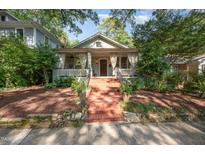 Charming home featuring a brick staircase leading to a cozy front porch with hanging curtains at 513 Cutler St, Raleigh, NC 27603