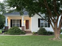 Charming single-story home featuring a cozy front porch, a well-manicured lawn, and lush landscaping at 526 Cardena School Rd, Fuquay Varina, NC 27526