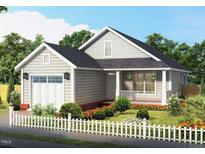 Charming single-story home boasts a manicured lawn, a white picket fence, and an attached garage at 701 East St, Smithfield, NC 27577