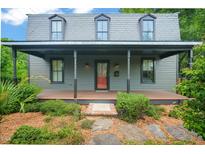 Charming home with covered front porch and dormer windows, framed by lush landscaping at 701 Holloway St, Durham, NC 27701
