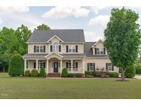 Stately two-story home with a welcoming front porch and meticulously landscaped lawn at 7217 Leando Dr, Willow Springs, NC 27592