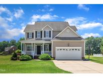 Charming two-story home featuring a welcoming front porch, two-car garage, and well-maintained lawn at 86 Woodall Farm Ln, Princeton, NC 27569