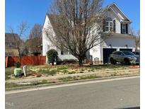 Two-story home featuring an attached two-car garage, mature landscaping, and neutral siding at 917 Widewaters Pkwy, Knightdale, NC 27545