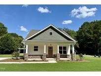 Charming home featuring a welcoming front porch, stone accents, and a well-manicured lawn at 172 W Old Rd, Lillington, NC 27546