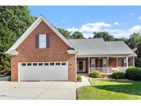 Charming brick home featuring a two-car garage and inviting front porch at 175 Georgetown Woods Dr, Youngsville, NC 27596