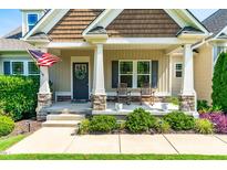 Inviting front porch with rocking chairs and an American flag for a warm and welcoming feel at 20 Kola Nut, Smithfield, NC 27577